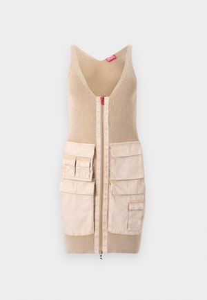 Rochie vestă tricotată bej cu textură nervurată, având un fermoar central și două buzunare mari cu clapete pe fiecare parte. Etichetă de brand roșie vizibilă.