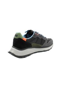 Scarpa sportiva da uomo caratterizzata da una combinazione di materiali grigi e neri, dettagli in suede testurizzato, lacci blu e un tallone multicolore.