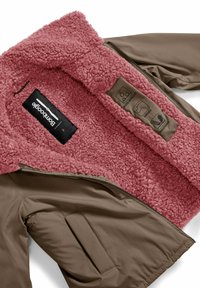 Bruine buitenjas met roze, zachte fleece voering. Voorzien van zijzakken en zorglabels. Ritssluiting aan de voorkant.