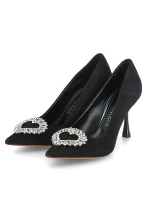 Chaussures à talons hauts noires en nubuck avec des bouts pointus, ornées d'un détail en strass en forme de cœur à l'avant. Texture lisse, talons de 3 pouces.