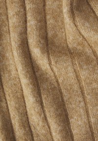 Textured mustard-yellow knit fabric with alternating raised and flat lines, creating a wavy pattern. Soft and slightly fuzzy texture.