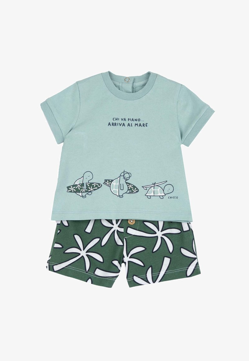 Tenue pour enfants composée d'un t-shirt en coton vert clair imprimé de tortues et de texte, associé à un short vert foncé avec des motifs de feuilles de palmier blanches.