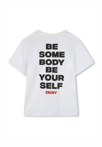 Witte katoen t-shirt met korte mouwen, voorzien van vet zwart tekst op de achterkant: "WEES IEMAND WEES JEZELF" en een rood "DKNY" logo.