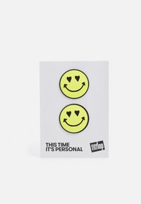 Adesivos de caras sorridentes amarelas com corações nos olhos, exibidos num cartão branco com texto preto que diz "Desta vez é pessoal."