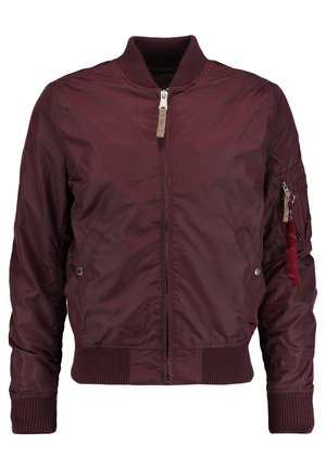 Burgundy színű bomber dzseki sima anyagból; elöl cipzárral, bordás mandzsettákkal, oldalsó zsebekkel és egy piros szalaggal díszített funkcionális zsebből áll.