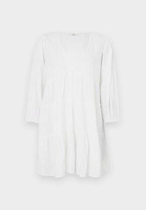 Witte, gelaagde jurk van lichtgewicht stof met lange mouwen, een diepe halslijn en subtiele verticale textuurdetails.
