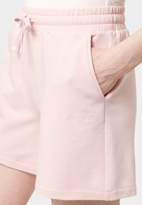 Světle růžové bavlněné šortky s elastickým páskem, nastavitelným šňůrkou, bočními kapsami a vypouštěným logem "LES LUNES" na nohavici.