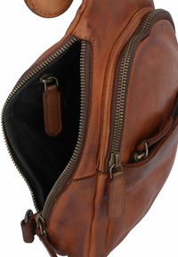 Borsa in pelle marrone con cerniere visibili e superficie testurizzata. L'interno presenta un rivestimento scuro e una piccola tasca laterale.