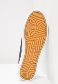 Semelle de chaussure avec motif en caoutchouc marron, taille 37 indiquée et nom de marque Marc O'Polo embossé au centre.