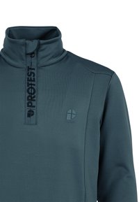 Tamsiai mėlyna ketvirčio užtrauktuko fliso puloveris su aukštu apykakle, turintis logotipą, spausdintą vertikaliai, ir iškilų logotipą ant krūtinės. Minkšta tekstūra.