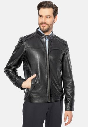 Giacca in pelle nera da uomo con chiusura zip frontale, collo alla coreana, due tasche laterali con zip e una texture liscia con dettagli delle cuciture.