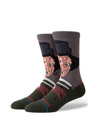 Calcetines de algodón con un diseño gráfico de la cara de un personaje, en una paleta de colores marrón y gris, con un sombrero negro y acentos de rayas verdes.