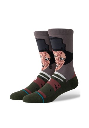 Calcetines de algodón con un diseño gráfico de la cara de un personaje, en una paleta de colores marrón y gris, con un sombrero negro y acentos de rayas verdes.