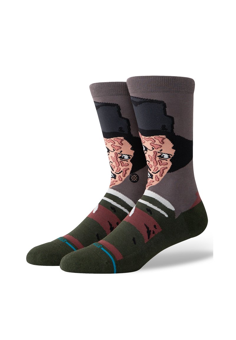 Calcetines de algodón con un diseño gráfico de la cara de un personaje, en una paleta de colores marrón y gris, con un sombrero negro y acentos de rayas verdes.