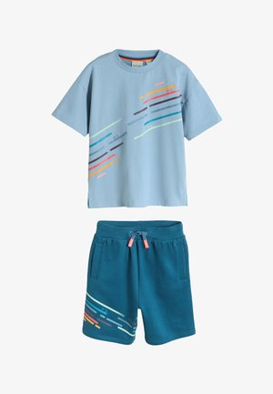 Hellblaues kurzärmeliges T-Shirt mit mehrfarbigen diagonalen Streifen und passenden dunkel petrolfarbenen Shorts mit Kordelzug und Streifendesign am linken Bein.