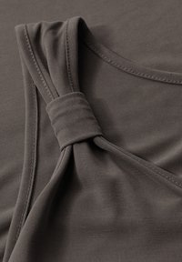 Top grigio senza maniche con dettaglio a nodo attorcigliato sulla spalla, realizzato in un tessuto morbido e elasticizzato.
