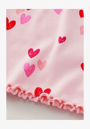 Różowa prążkowana tkanina z małymi sercami w kolorze czerwonym, różowym i brzoskwiniowym. U dołu znajduje się falbankowaty brzeg, który dodaje tekstury wzorowi.