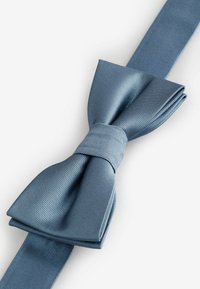 Sinine siidist kikilips tekstuurse viimistlusega, keskosas sõlmega ja laiade, lamedate otstega, mõeldud ametlikeks sündmusteks.