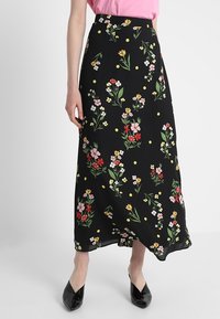 Černá květinová sukně s vzorem barevných květin a žlutými tečkami. Vyrobena z lehkého materiálu s volným střihem a v délce po kotníky.
