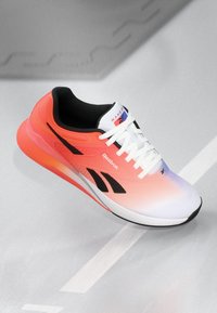 Reebok running shoe with a breathable mesh upper in gradient pink to white. Features black accents, flat laces, and a cushioned sole.