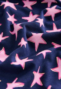Jūras spēku audums ar gludu tekstūru, kas satur lielus rozā zvaigznes, apzīmētas ar gaiši rozā, izkārtotas izkaisītā rakstā visā virsmā.