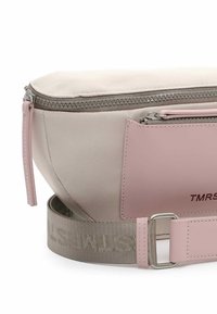 Banane beige et rose avec fermeture éclair, poche avant et sangle en tissu réglable avec détails cousus.
