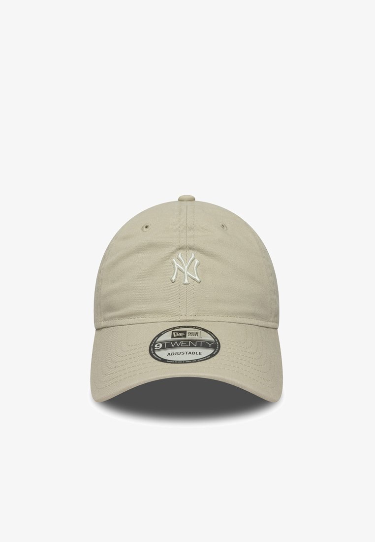Beige adjustable baseball cap with the New York Yankees logo stitched on the front, featuring a curved bill and cotton texture.