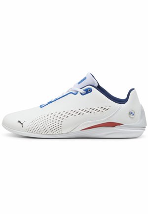 Baskets blanches à profil bas avec des accents bleus, des détails latéraux perforés, une bande rouge près de la semelle et un petit logo Puma à l'avant.