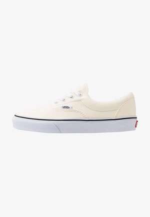 Niedriger weißer Vans Sneaker mit weißen Schnürsenkeln, schwarzem Streifen auf weißer Gummisohle und Vans-Logo-Label an der Seite.