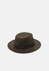 Brown cotton bucket hat with a wide brim, rounded crown, and two ventilation eyelets. Smooth texture with a stitched band around the base.