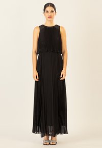 Schwarzes, plissiertes Maxikleid mit rundem Ausschnitt und ärmellosem Design. Der Stoff fällt weich und schafft eine fließende Silhouette. Eleganter, einfacher Stil.