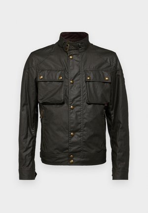 Temno zelena voščena bombažna jakna z visokim ovratnikom, zlatimi dodatki, dvema žepoma na prsih in zadrgo na strani. Gladka tekstura, robusten dizajn.