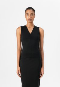 Top senza maniche nero con scollatura a V, caratterizzato da dettagli arricciati sul davanti. Realizzato in tessuto liscio, il design aderente enfatizza la silhouette.