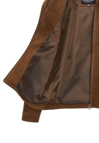 Bruine suedejas met een gladde, bruine satijnen voering, voorzien van een ritsluiting en een zijzak. Strakke en moderne designelementen.