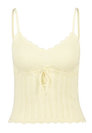 Knit camisole in light yellow with scalloped edges, ribbed texture, and a drawstring detail at the waist. Sleeveless with thin straps.