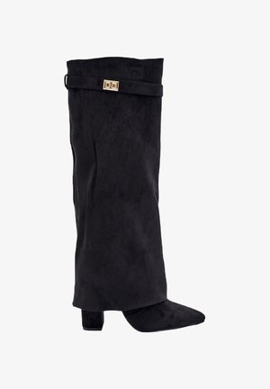 Botte en suede noir avec une tige montée jusqu'au genou, un bout pointu, un talon carré et un accent en métal doré sur la sangle supérieure.