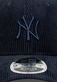 Ναυτικό μπλε καπέλο κοτλέ με κεντημένο λογότυπο New York Yankees. Διαθέτει ρυθμιζόμενο ιμάντα και γυαλιστερή ετικέτα 9FORTY M-CROWN στη γείσο.
