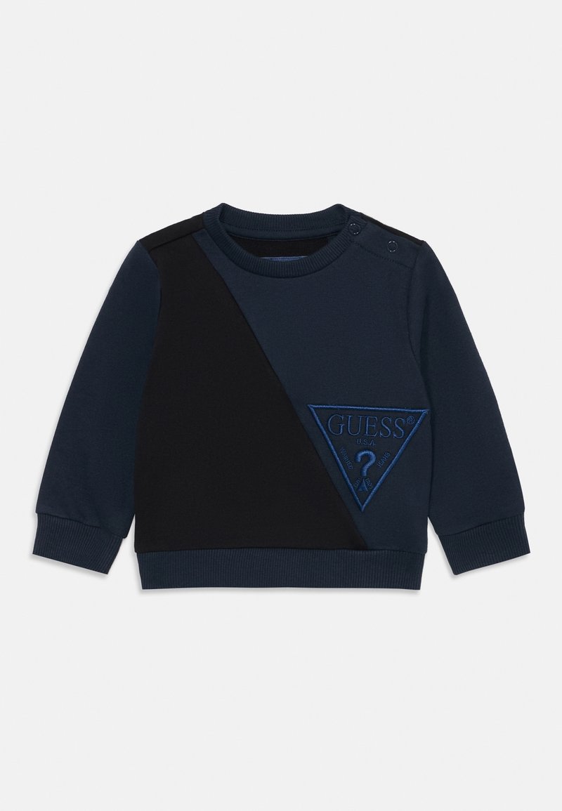Sweat-shirt bleu marine à manches longues pour tout-petit avec un panneau diagonal noir et le logo triangulaire GUESS brodé en bleu sur le devant.