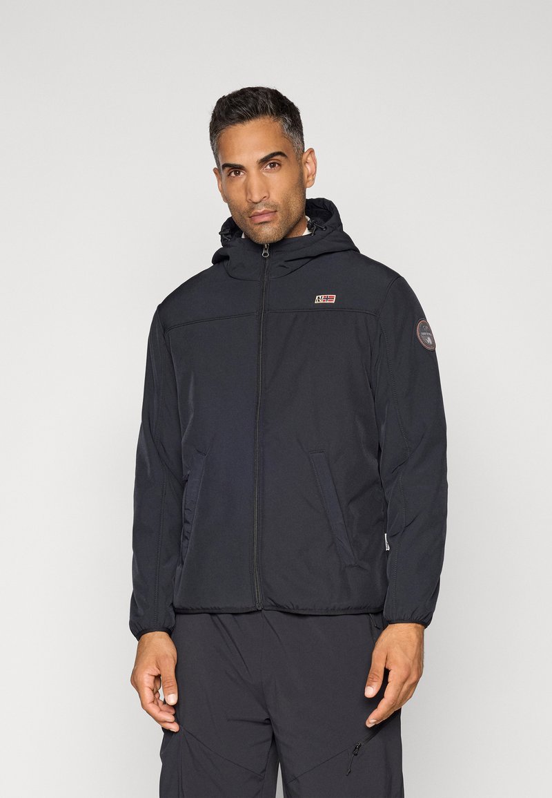 Veste isolante noire avec fermeture éclair, capuche ajustée, poches latérales et un patch logo sur la poitrine. Texture lisse, design moderne.