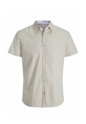 Kortermet beige skjorte med knapper, liten mørk prikkete mønster og klassisk krage, vist på hvit bakgrunn.