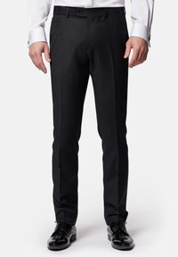 Czarne formalne spodnie o dopasowanym kroju, z gładką teksturą, paskiem na pasek i płaskim przodem. W połączeniu z błyszczącymi czarnymi butami.