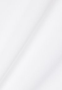 Weißer, strukturierter Stoff mit einer dezenten diagonalen Falte, der ein feines Netzmuster und weiche Falten auf einem schlichten Hintergrund zeigt.