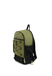 Mochila de nailon verde con acentos negros, diseño de cordón elástico en la parte delantera, correas ajustables y bolsillo de malla lateral. La parte inferior cuenta con dobles hebillas.