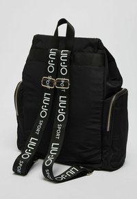 Czarny nylonowy plecak z złotymi detalami zamka, regulowane paski z logo "LIU JO Sport" oraz usztywniony kształt.