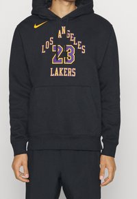 Haut à capuche noir en tissu doux avec l'inscription "Los Angeles Lakers" en lettres violettes et jaunes, avec une capuche à cordon et une poche frontale.