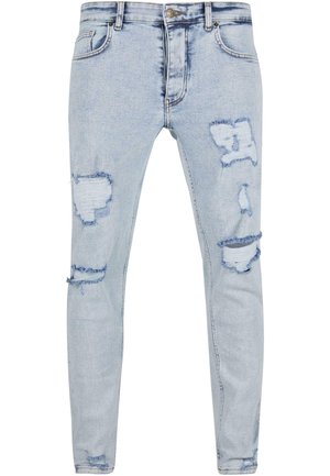 Svijetloplave traperice slim fit kroja s istrošenim dijelovima i rastrganim rubovima. Klasičan dizajn s pet džepova i metalnim dodacima.