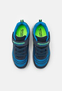 Baskets Skechers S-Lights, bleu marine avec des accents verts, en tissu texturé, design rayé, strap ajustable et fermeture à lacets.