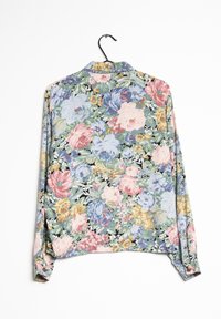 Bloemige langefsleef shirt met een meerkleurig patroon van roze, blauwe en gele bloemen tegen een donkere achtergrond, gemaakt van lichtgewicht stof.