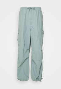 Ljusgröna, löst sittande byxor med elastisk midja, snörning och sidofickor i cargo-stil. Tillverkade av mjukt, lättviktigt material.