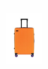 Twarda walizka w jaskrawym pomarańczowym kolorze z pionowymi liniami, wysuwanym czarnym uchwytem i czterema fioletowymi kółkami dla łatwej mobilności.